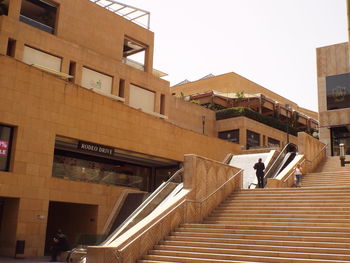 Low angle view of steps amidst buildings against clear sky