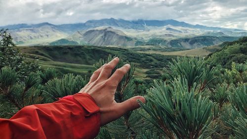 Midsection of person on mountain against sky