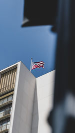 Low angle view of flag against building in city