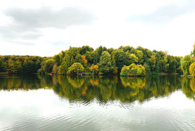 Scenic view of lake by trees against sky