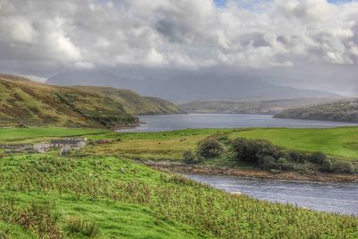 Scenic view of river and mountains against sky