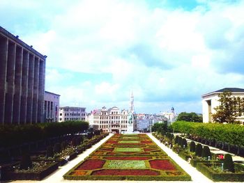 View of city street against cloudy sky