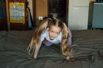 Portrait of a smiling child, listening to music in white headphones, dancing, fooling around at home