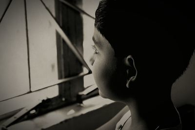 Close-up of boy looking through window