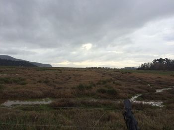 Scenic view of landscape against cloudy sky