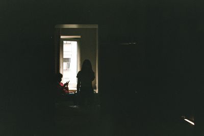 Silhouette people sitting at entrance of building