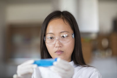 Scientist female with lab glasses and tubes in a lab