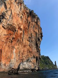 Rock formation in sea against clear sky