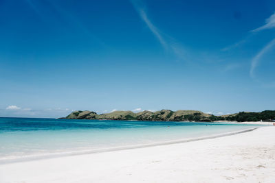 Scenic view of beach against blue sky