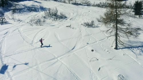 High angle view of man skiing on snowy field during sunny day