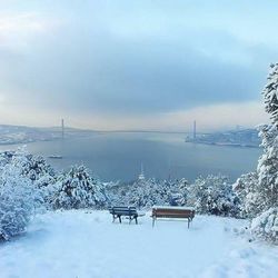 Scenic view of snow covered mountains against cloudy sky