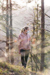 Portrait of young man standing in forest