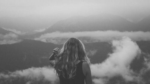 Woman against cloudy sky