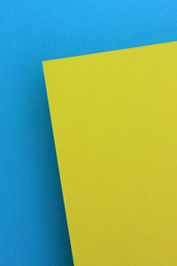 Close-up of yellow paper against blue background