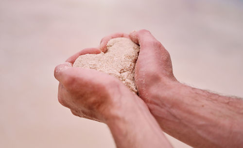 Cropped hand of person holding sand