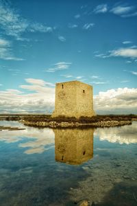 Built structure in lake against sky