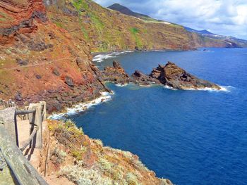 Scenic view of sea and mountains against sky