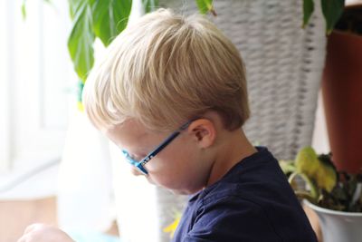 Close-up portrait of boy with glasses looking away