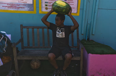 Full length of girl sitting on wall