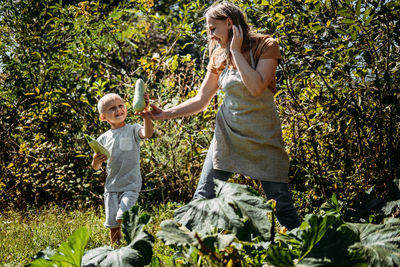 Green thumbs, spring is here, home gardens and picking vegetables. happy family, mom and kid