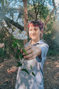 Portrait of young woman standing in forest