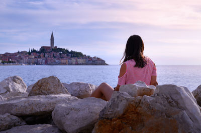 Rear view of woman looking at sea against sky