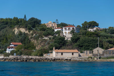 Buildings by sea against sky in city