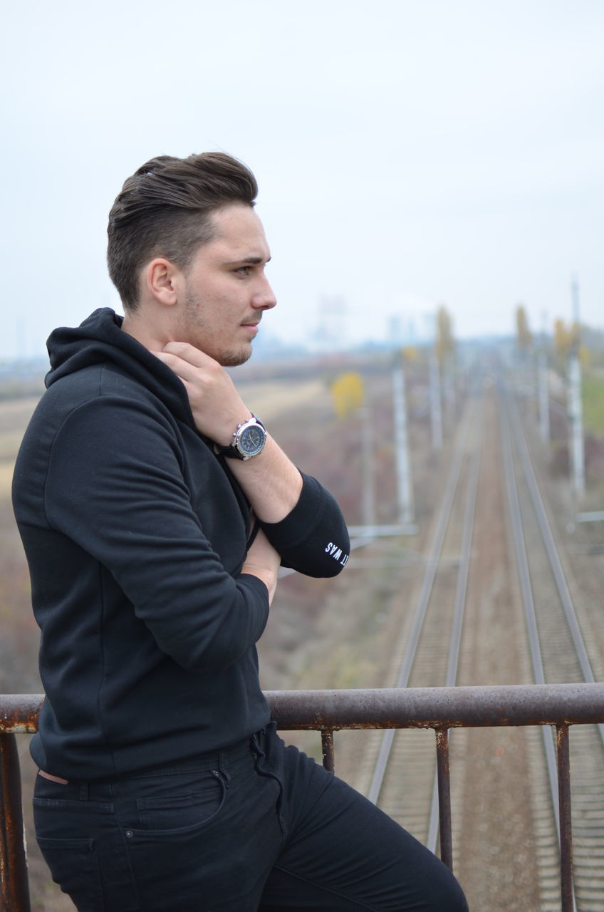 railroad track, focus on foreground, real people, outdoors, one person, day, lifestyles, sky, men, young adult, people