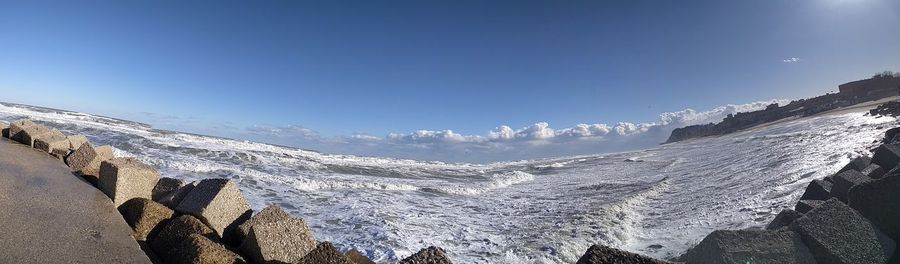 Low angle view of snow mountains against blue sky