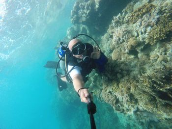 Scuba diver taking selfie in sea