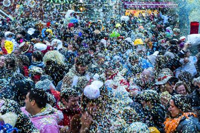 Crowd throwing colorful confetti in city during celebration