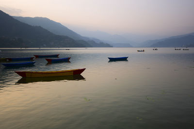 Boats moored in lake against sky