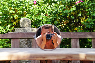 Reflection of man photographing in mirror