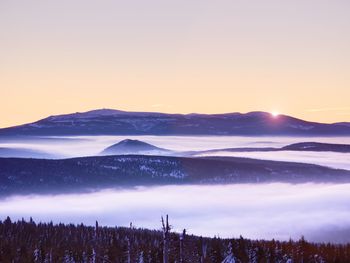 Scenic view of snowcapped mountains against sky during sunset