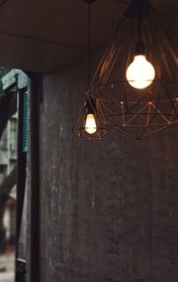 Low angle view of illuminated pendant light hanging from ceiling