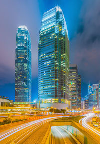 Illuminated modern buildings in city against sky