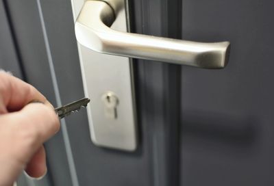 Close-up of hand holding metal door