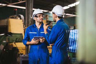 Portrait of young man standing in factory