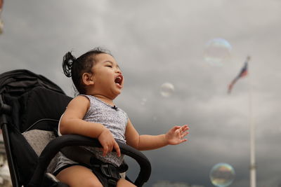 Full length of happy boy looking at bubbles