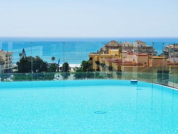View of swimming pool by sea against clear sky