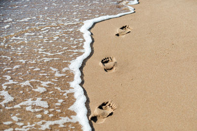 High angle view of footprints on sand at beach