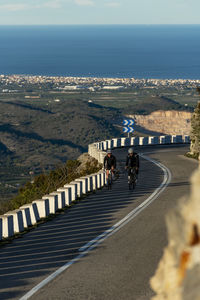 Sportsman and sportswoman cycling on mountain pass, alicante, spain