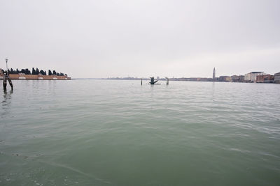 Scenic view of sea by buildings against sky