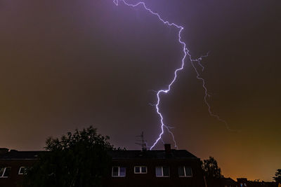 Low angle view of lightning against buildings at night