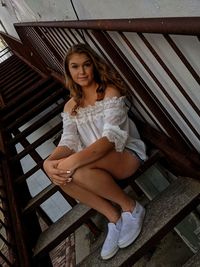 Portrait of woman sitting on staircase