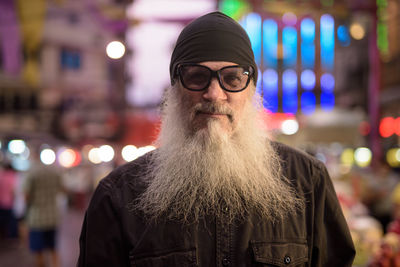 Portrait of man wearing hat standing at night