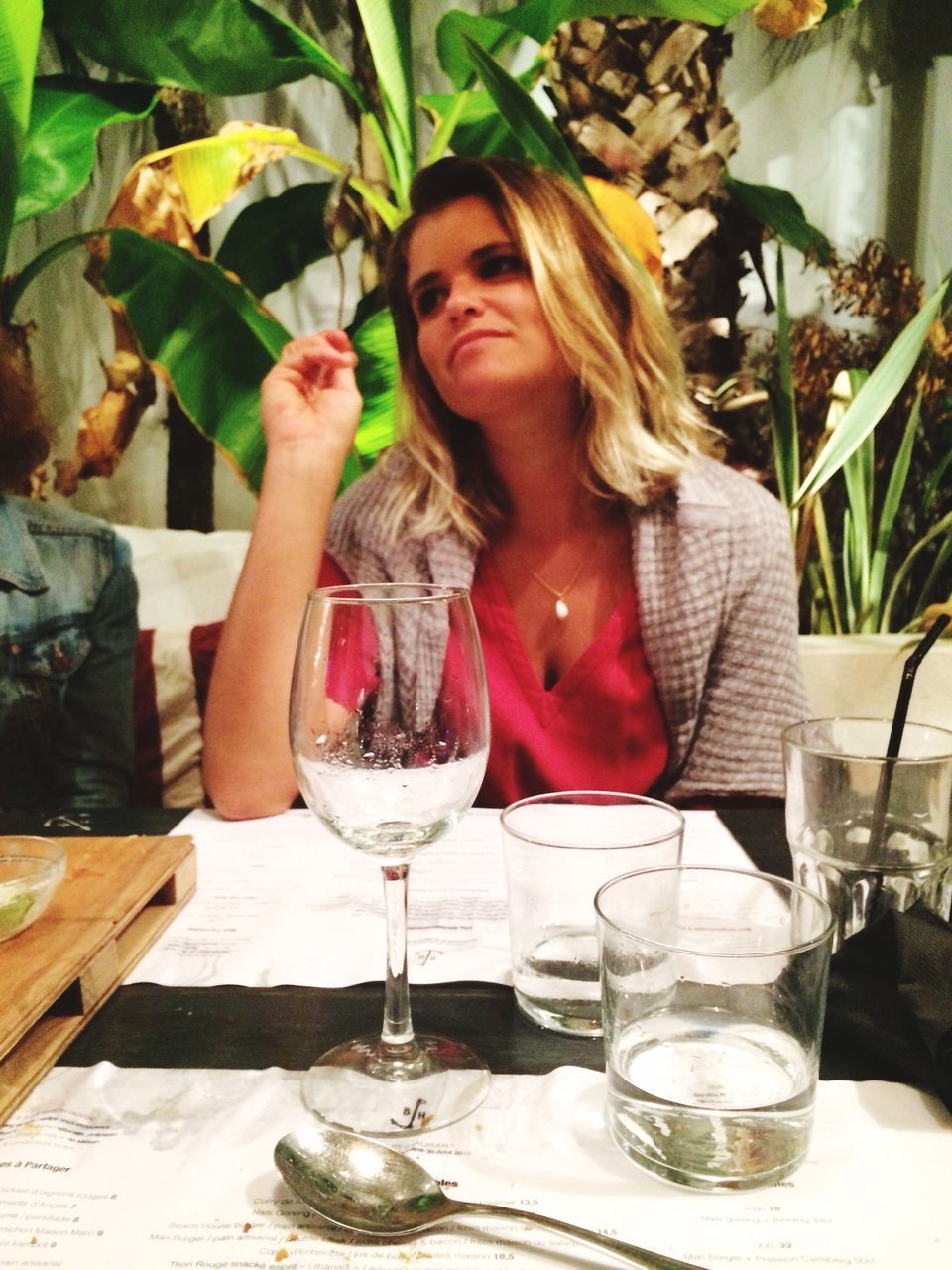 YOUNG WOMAN SITTING ON TABLE IN FRONT OF RESTAURANT