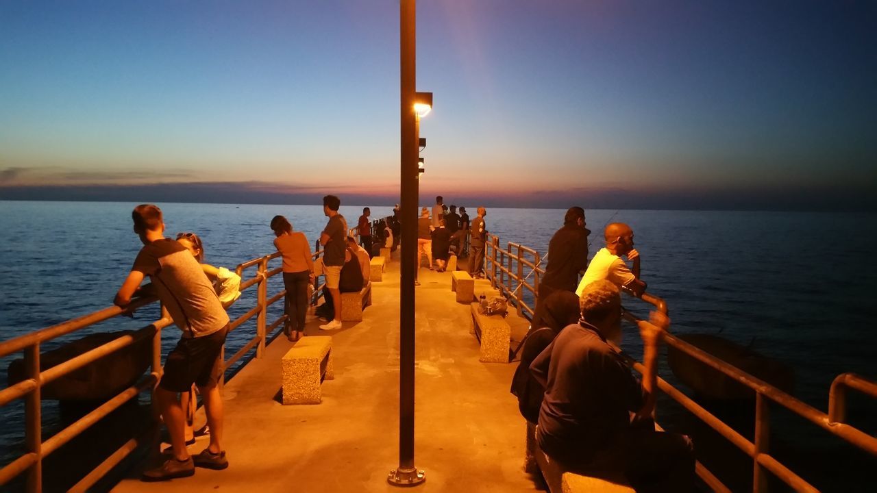 sky, water, sea, group of people, real people, horizon, horizon over water, railing, nature, scenics - nature, leisure activity, large group of people, beauty in nature, lifestyles, crowd, men, standing, nautical vessel, clear sky, outdoors