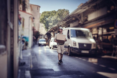 Woman walking on road in city
