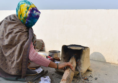 Rural woman cooking food on fire wood